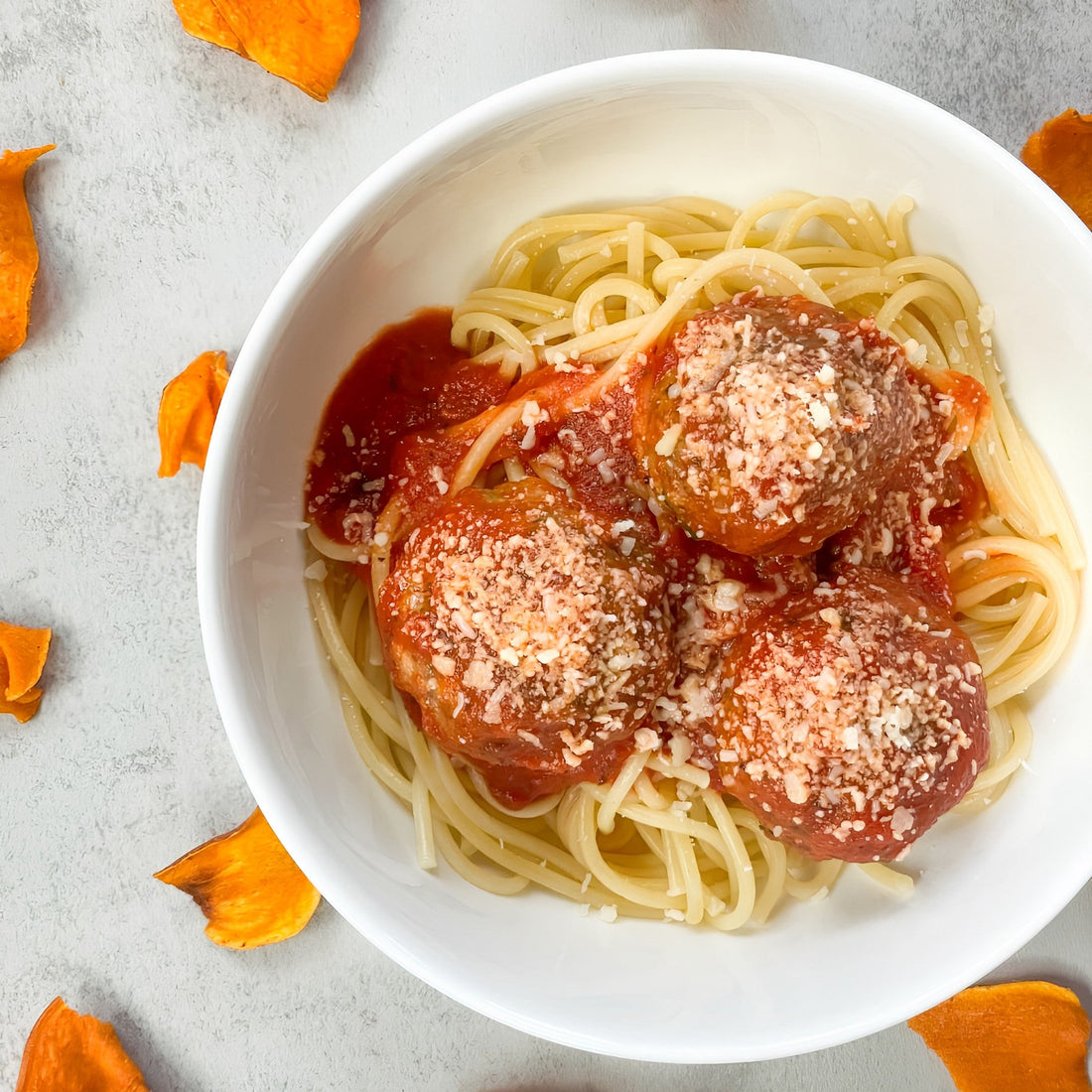 Bowl of spaghetti and meatballs with Jackson's sweet potato chips surrounding the bowl.