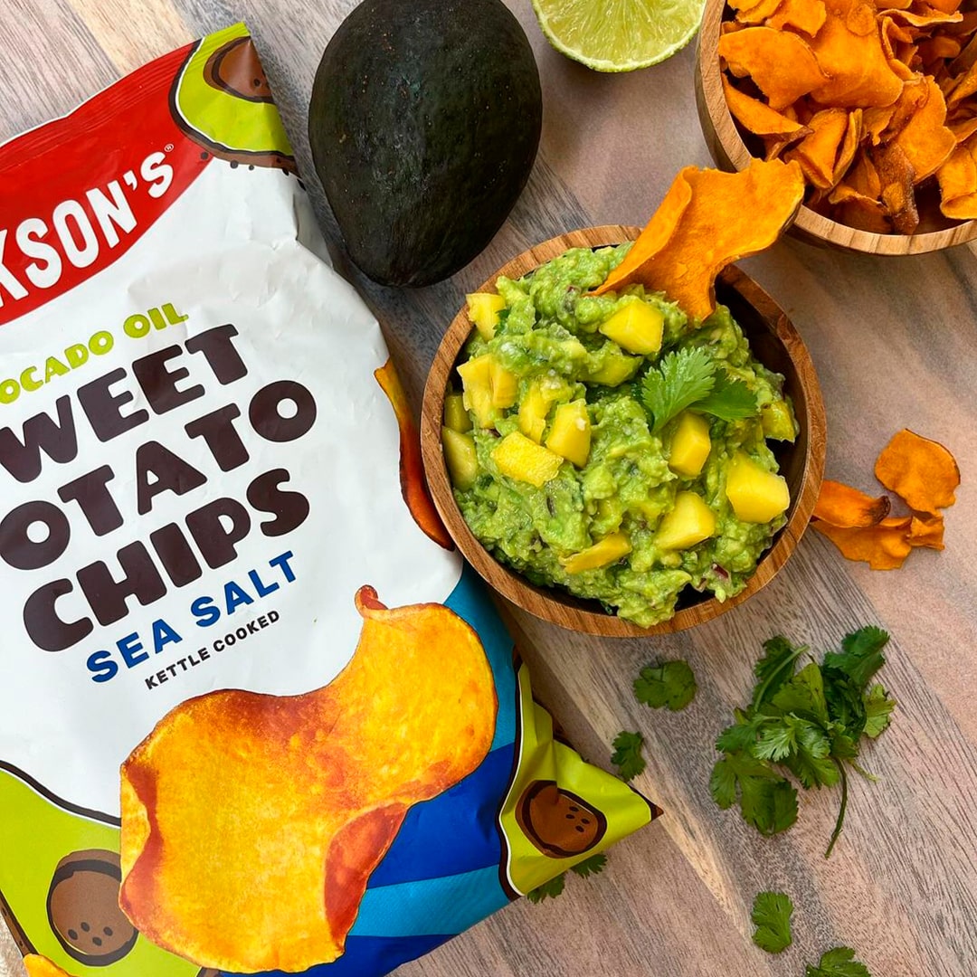 Mango guacamole in a bowl with bag of Jackson's Sea Salt Sweet Potato Chips on the side.