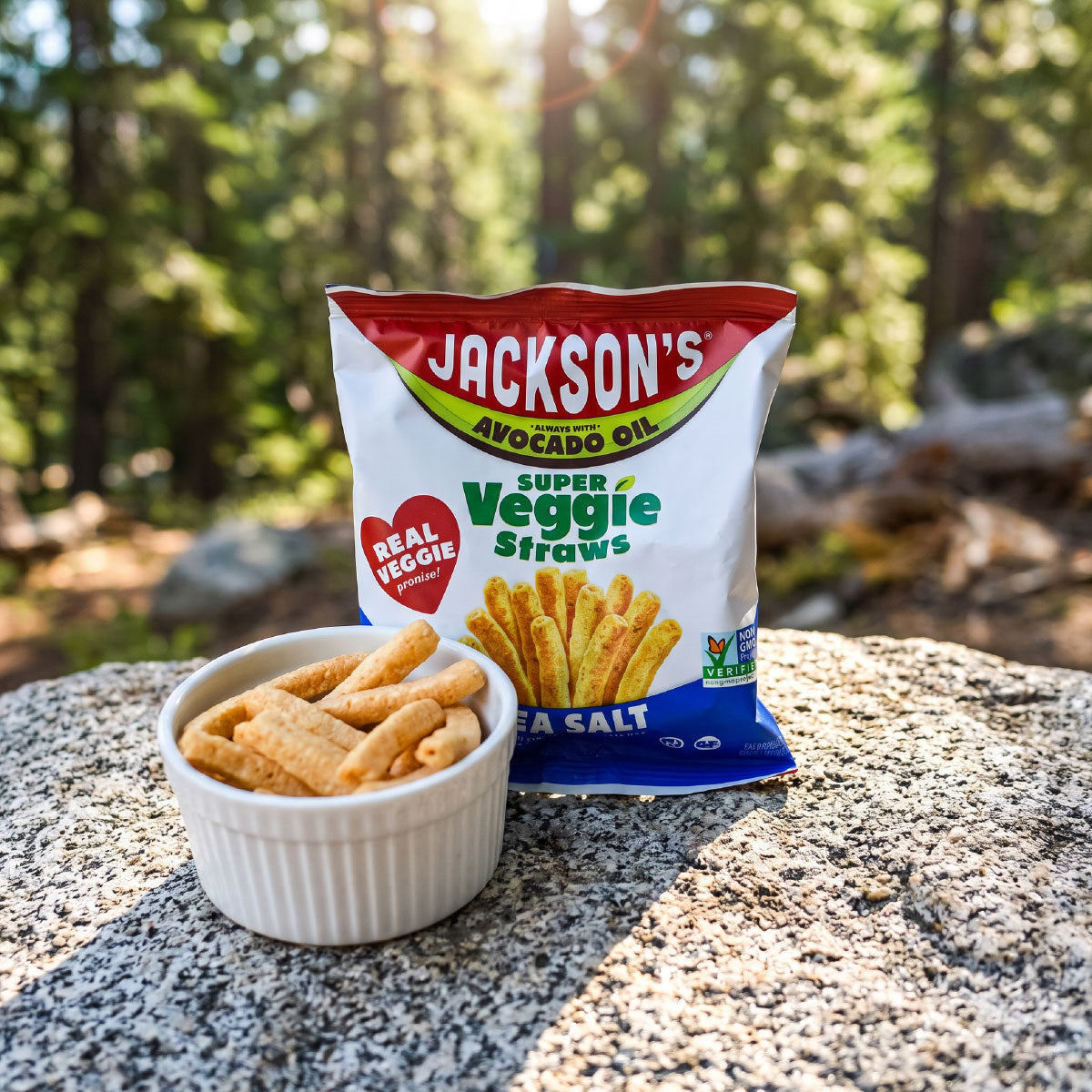 super veggie straws outdoors on a rock with a small bowl filled with super veggie straws