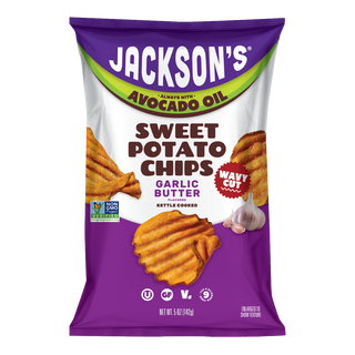 Front of a 5 oz bag of Jackson’s Garlic Butter Flavored Wavy Cut Sweet Potato Chips, kettle cooked, always with avocado oil. Purple and white bag with a lime green arc, golden-orange wavy-cut chips, a garlic bulb, a red “Wavy Cut” badge, and Non-GMO Project Verified, Kosher, Gluten Free, Vegan and Top 9 Allergen Free icons.
