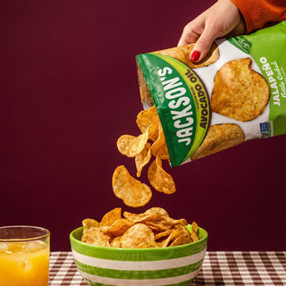 Jackson's jalapeno kettle chips poured into a bowl with chips flying around