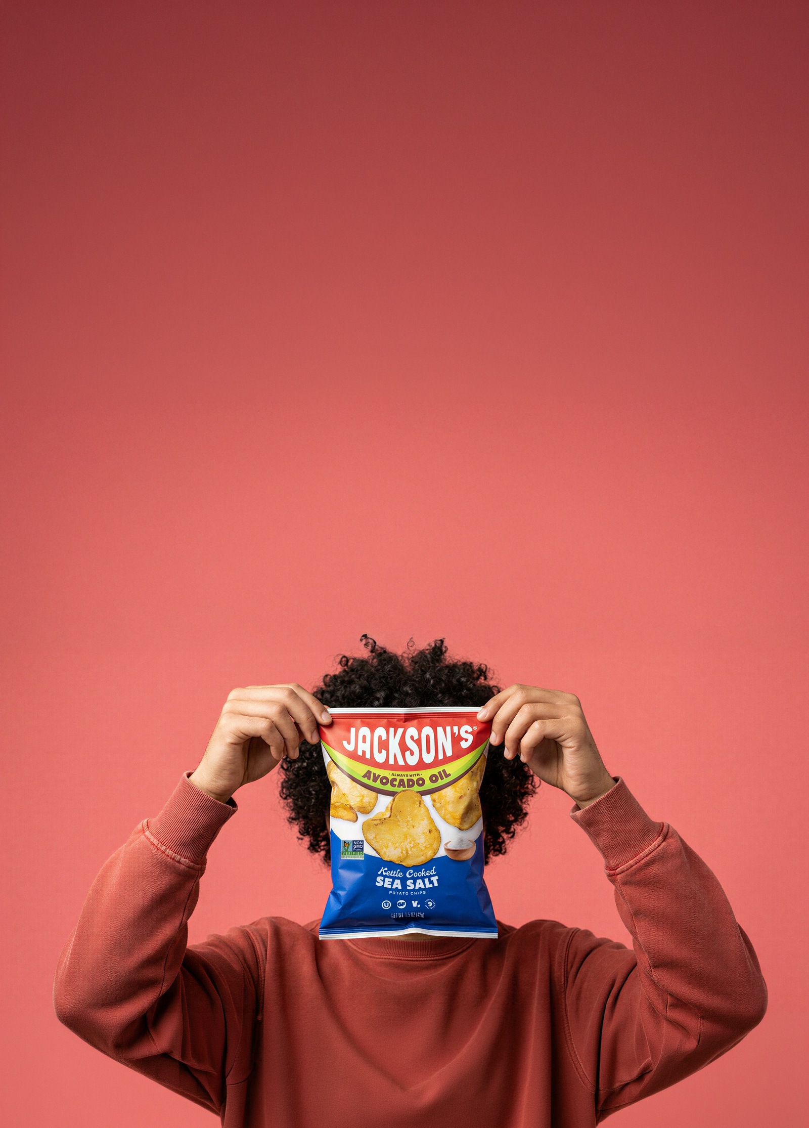 Person holding a bag of Jackson's kettle chips to their face